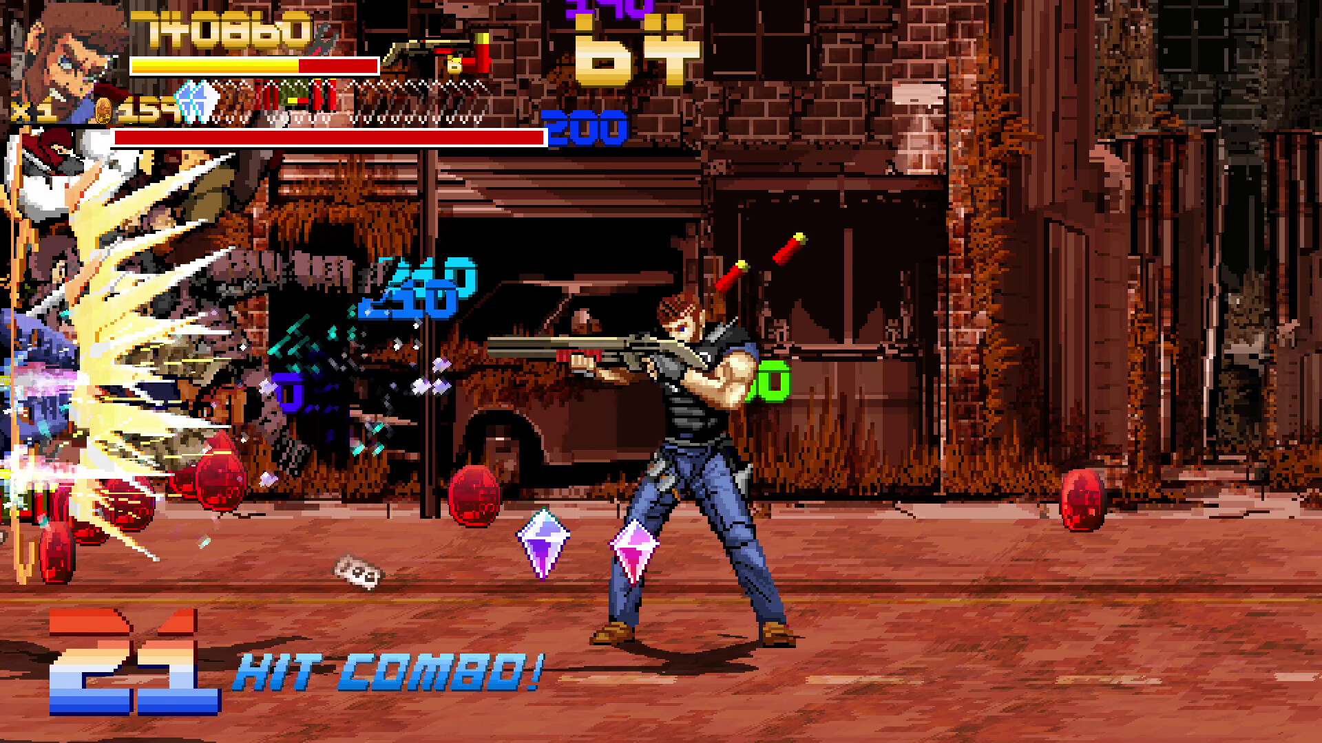 The image shows a pixel-art style video game scene set in an urban, rundown environment with brick buildings and overgrown vegetation in the background. A muscular character wearing a black sleeveless shirt and blue jeans is aiming and firing a shotgun to the left side of the screen, with shotgun shell casings visibly ejecting behind him. Explosions and impact effects are present on the left, accompanied by floating numerical damage indicators and a “21 HIT COMBO!” message at the bottom left, indicating continuous successful attacks. The character’s health bar, score, and other game UI elements are displayed at the top and left edges of the screen.