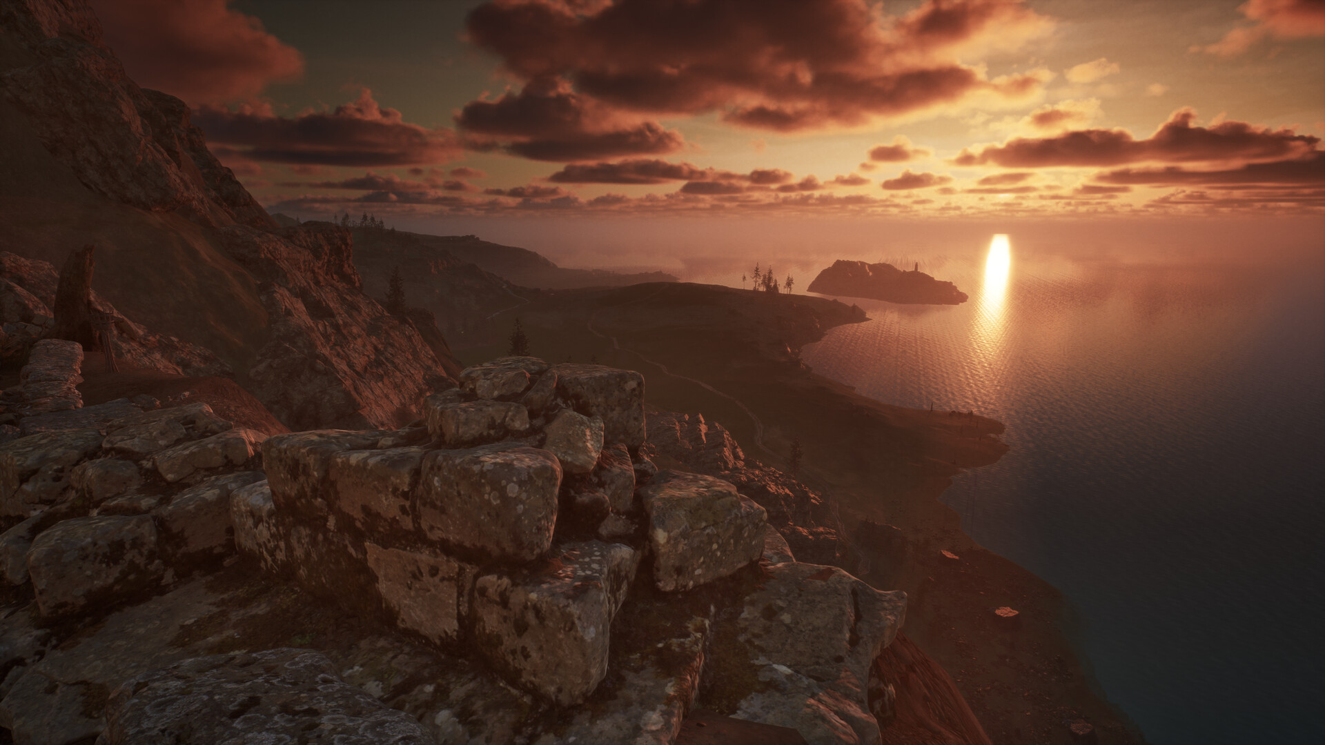 The image depicts a coastal landscape at sunset, with the sun low on the horizon casting a warm golden light across the scene. In the foreground, weathered stone blocks and rocky terrain dominate the view, giving a sense of ruggedness and age. Beyond the cliffs, a winding path leads toward a peninsula with sparse trees, while an island is visible off the coast, partially silhouetted by the glowing reflection of the sun on the calm ocean waters. The sky is filled with scattered clouds tinted orange and pink by the setting sun, enhancing the tranquil and expansive atmosphere.