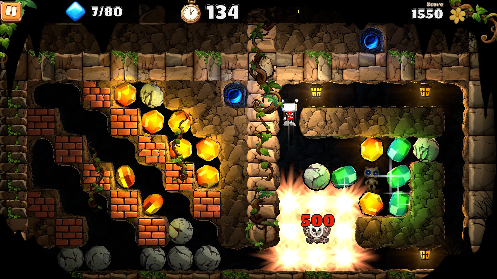 The image shows a colorful, side-scrolling video game scene set inside a cave with stone and brick walls intertwined with green vines. Large, glowing yellow and green gems are scattered throughout the cave, some embedded in the walls and others floating. Near the center, a small character with a red and white striped hat is jumping or falling past two glowing blue portals embedded in the stone. At the bottom right, a bright explosion with the red number "500" appears, illuminating two small creatures-one looks like a fuzzy animal caught in the blast, while the other stands nearby with big blue eyes. Game interface elements display a pause button, collected gems count "7/80," a timer at "134," and a score of "1550."