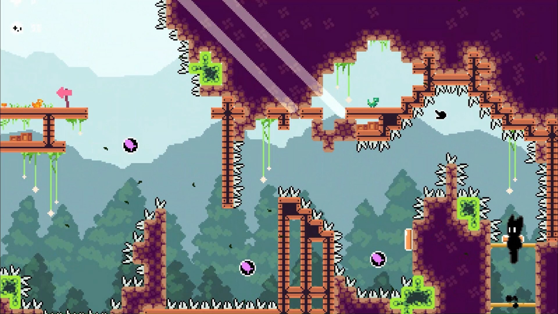 The image depicts a pixel-art style platform game scene set against a backdrop of misty blue-green forested mountains. The terrain consists of irregular brown and purple rocky platforms studded with white spikes, creating hazardous obstacles for the character. The platforms are connected by wooden ladders and beams, with green moss hanging and small plants growing intermittently. In the lower right, a black silhouette character with glowing white eyes stands on a narrow ledge. Purple-and-black circular bouncing objects float in the air, adding dynamic elements to the environment. The overall mood suggests a challenging level requiring precise navigation.
