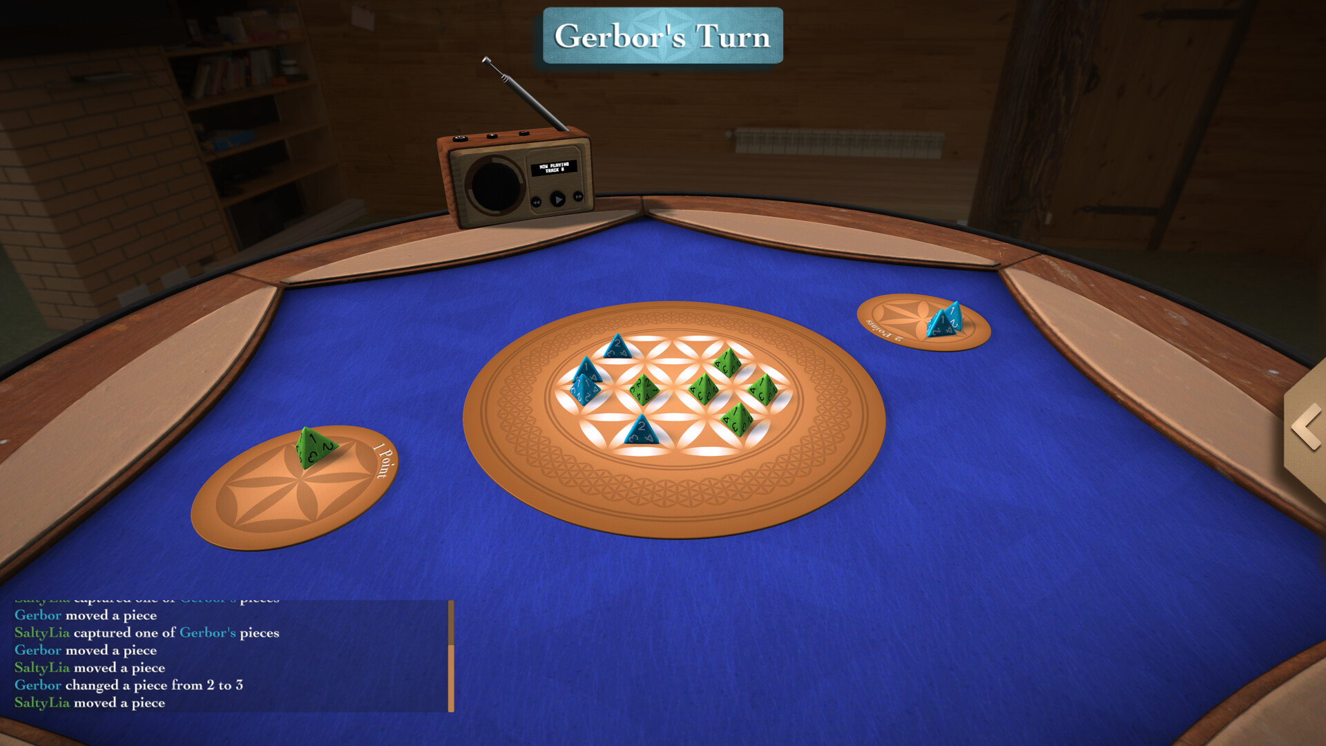 The image shows a close-up view of a tabletop game set on a blue felt surface with wooden edges. At the center, there is a circular board featuring an intricate geometric pattern with six small 4-sided dice (tetrahedrons) placed on it, three green and three blue. On either side of the board, there are two small oval mats labeled "1 Point" and "3 Points," each holding one die, green on the left and blue on the right. Above the table, a small vintage-style wooden radio with an antenna is positioned, and a text box at the top of the image reads "Gerbor's Turn," indicating it is a player’s move in the game. In the background, the scene appears to be set in a cozy, wood-paneled room with a bookshelf and a radiator visible.