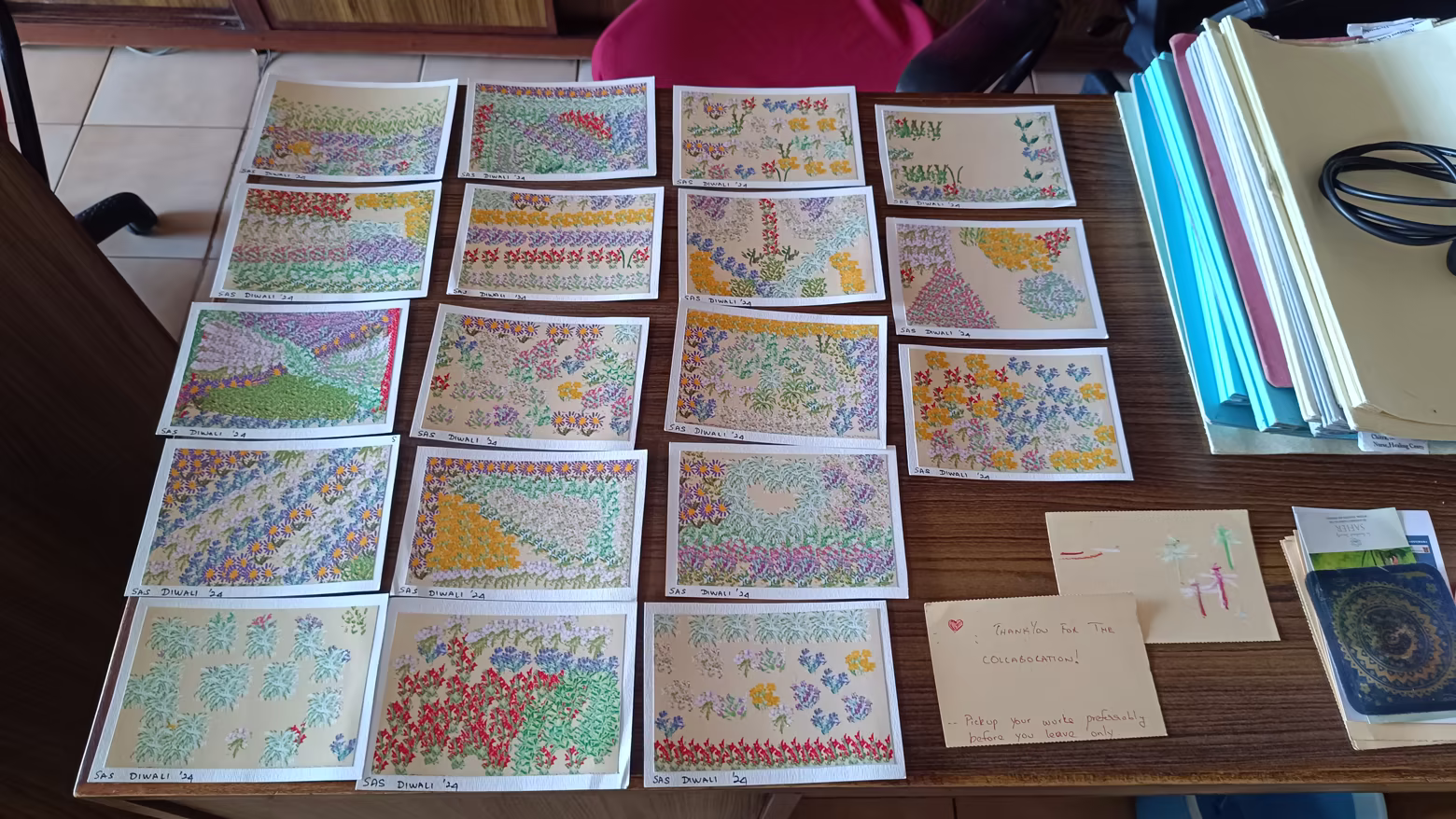 Printed Garden of Being postcards from a Diwali collaboration, laid out on a table - pastel gardens made by friends.